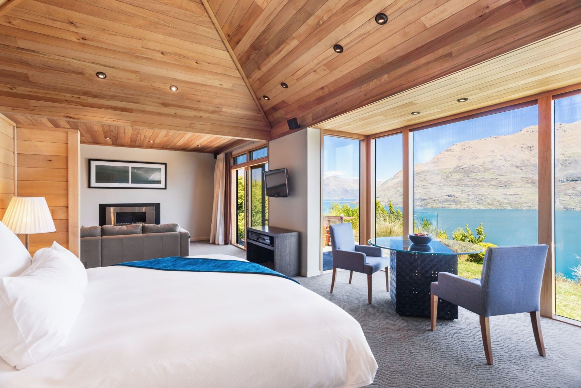 Luxury Suite lounge with stone fireplace and panoramic windows over the lake